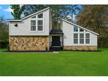Striking two-story home with modern windows, stone accents, and a lush green lawn at 5444 Wylstream, Norcross, GA 30093