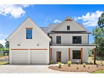 Charming two-story home featuring a symmetrical facade, two-car garage, and inviting front porch at 5125 Hyde Trl, Cumming, GA 30040