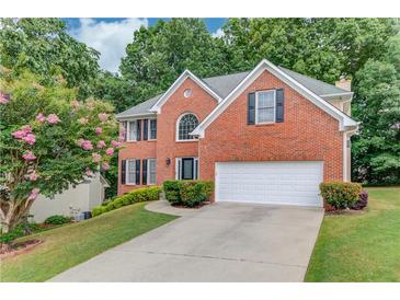 Charming brick two-story home with well-manicured lawn and a two-car garage at 1446 Chadwick Ridge Ct, Lawrenceville, GA 30043
