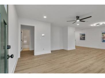 Bright living room featuring hardwood floors, ceiling fan, and freshly painted white walls at 2358 Tilson Rd, Decatur, GA 30032