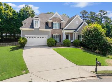Charming two-story home featuring a manicured lawn and brick and gray siding at 1539 School House Run, Dacula, GA 30019
