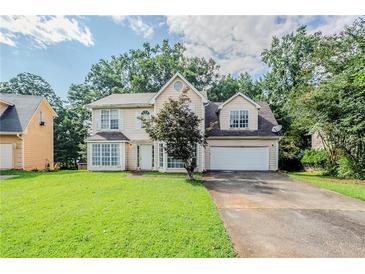 Inviting two-story home with a well-manicured lawn and attached two car garage at 3604 Cameron Hills Pl, Ellenwood, GA 30294