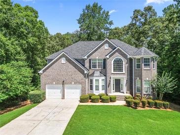 Traditional two-story brick home with well-maintained landscaping, three-car garage, and manicured front lawn at 3688 Eagles Beek Cir, Lithonia, GA 30038