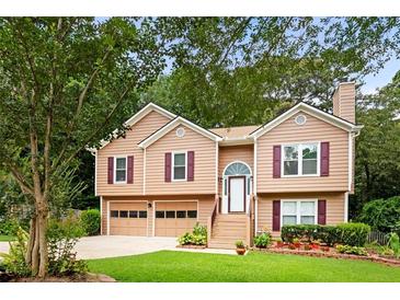 Charming two-story home with a well-manicured lawn, attached garage, and inviting entrance at 3049 Heathgate Ct, Lawrenceville, GA 30044