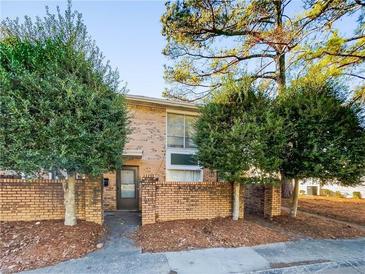 Inviting brick townhome featuring a secure front entrance surrounded by mature trees at 4701 Flat Shoals Rd # 68D, Union City, GA 30291