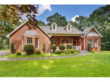 Charming brick home with a manicured lawn and mature trees at 1950 Lower Burris Rd, Canton, GA 30114