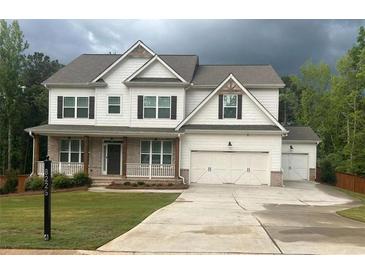 Charming two-story home with a large driveway, three-car garage, and beautifully maintained lawn at 8225 Crooked Creek Dr, Cumming, GA 30028