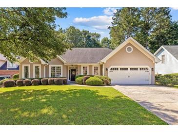 Charming single-story home with a well-manicured lawn, a two-car garage, and lush landscaping at 3072 Oaktree Ln, Duluth, GA 30096