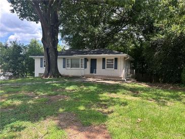 Charming single story house with a well-maintained lawn and tree and blue shutters at 3129 Nursery Rd, Smyrna, GA 30082
