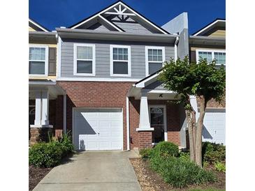 Charming two-story townhome with brick and gray siding, a single-car garage, and a well-maintained front yard at 776 Tulip Poplar Way, Lawrenceville, GA 30044