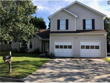 Charming two-story home with an attached two car garage and well-maintained lawn at 857 Asbury Trl, Lithonia, GA 30058