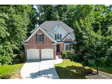 Charming brick two-story home with a two-car garage and lush landscaping at 1614 Summersweet Ln, Dacula, GA 30019