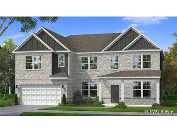 Charming two-story home with a gray brick exterior, complemented by a well-manicured lawn and lush landscaping at 2820 Dolce Rd, Dacula, GA 30019