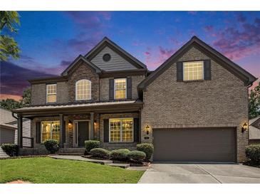 Beautiful two-story brick home with a well-manicured lawn and inviting front porch at dusk at 1883 Jameson Cir, Lawrenceville, GA 30043