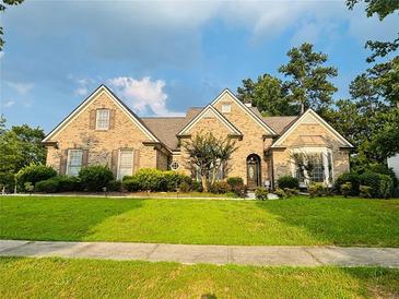 Charming single-story brick home with manicured lawn and mature landscaping, offering classic curb appeal at 3545 Renaissance Cir, Atlanta, GA 30349