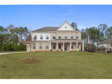Elegant two-story brick home with a columned front porch and a spacious front yard at 185 Haverling Pass, Hampton, GA 30228