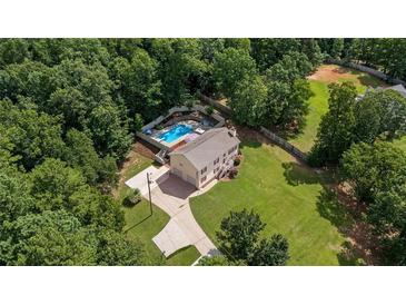Aerial view of two story home with a large pool, long drive, and mature trees at 450 Ledbetter Rd, Villa Rica, GA 30180