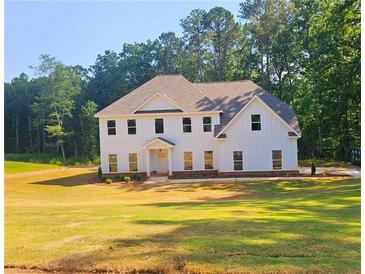 Striking white two-story modern farmhouse with a symmetrical facade and verdant lawn at 790 Turner Rd, Mcdonough, GA 30252