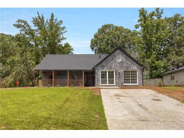 Charming one-story home featuring modern brickwork, a cozy front porch, and a well-manicured lawn at 8689 Cedar Creek Rdg, Riverdale, GA 30274