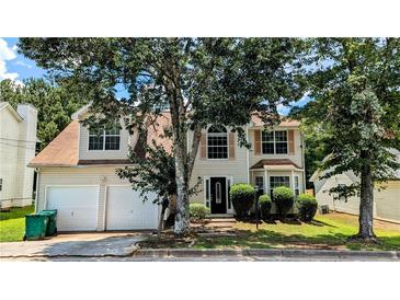 Charming two-story home featuring a well-maintained front yard, classic shutters and an attached two-car garage at 3679 Waldrop Cliff Ln, Decatur, GA 30034