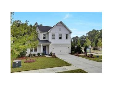 Two story home with a manicured lawn, gray siding, black roof, attached two car garage, and a blue front door at 722 Ocmulgee Xing, Locust Grove, GA 30248