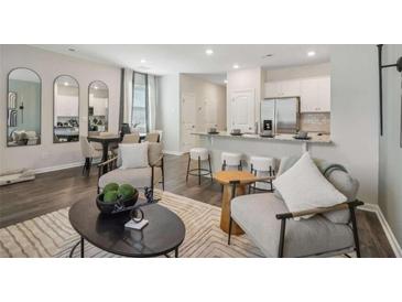 Open-concept living room featuring modern decor, hardwood floors, and a view of the kitchen at 1400 Sweetshrub Pl # 33, Atlanta, GA 30318