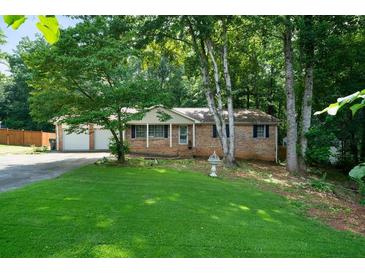 Charming single-story home with a well-maintained lawn and a two-car garage at 5070 Maryland Nw Dr, Acworth, GA 30101