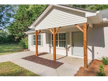 Charming home front porch with wooden supports, white siding, and updated landscaping at 1834 Stroud Road, Mcdonough, GA 30252