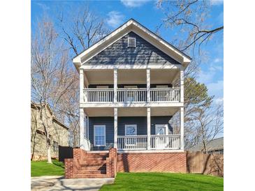 Charming two-story home with a double front porch, brick foundation, and nicely manicured lawn at 2395 Saint James Nw Dr, Atlanta, GA 30318