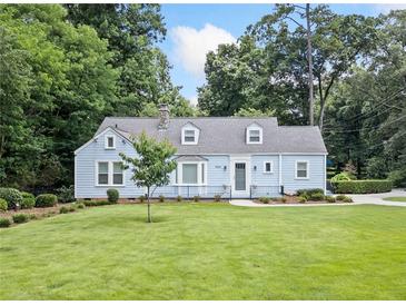 Charming light-blue home with a well-maintained lawn and manicured landscaping at 2830 Alston Drive Se Dr, Atlanta, GA 30317