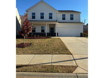 Charming two-story home with a well-manicured lawn, and a two car garage at 136 Paulownia Cir, Mcdonough, GA 30253