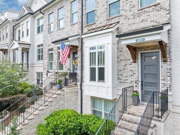 Charming townhome exterior with gray brick, a gray door, and an inviting entrance with steps at 4311 Parkside Pl, Atlanta, GA 30342