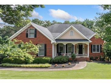 Charming single Gathering brick home with well-manicured lawn and inviting front porch seating area at 207 Breckenridge Ct, Canton, GA 30115