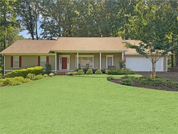 Charming single-story home featuring a well-manicured front lawn and an attached two car garage at 2251 Stag Run Run, Suwanee, GA 30024