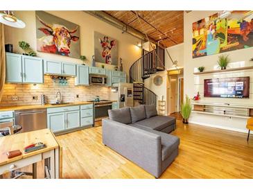 Open-concept living space featuring spiral staircase, modern kitchen, exposed brick, and eclectic decor at 10 James St # 11B, Hampton, GA 30228