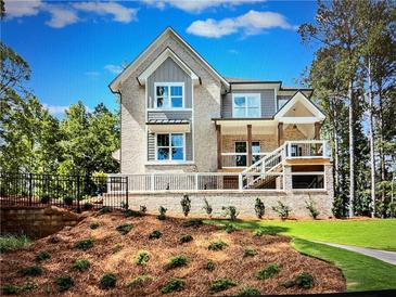 Charming two-story home with a brick facade and a well-manicured front yard at 1005 Liberty Springs Dr, Woodstock, GA 30188