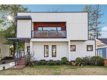 Modern two-story home with a balcony, dark trim, light-colored siding, and manicured landscaping at 1740 S Gordon Sw St, Atlanta, GA 30310