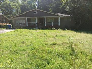 Charming home with a front porch and overgrown front yard, perfect for renovation at 3072 Will Rogers Se Pl, Atlanta, GA 30316