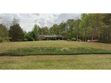 Charming single-story home with an attached carport and a lush green front yard at 820 Bennett Rd, Powder Springs, GA 30127