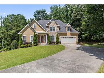 Charming tan home features a stone facade, well-manicured lawn, and an attached two-car garage at 2709 Gentry Dr, Douglasville, GA 30135