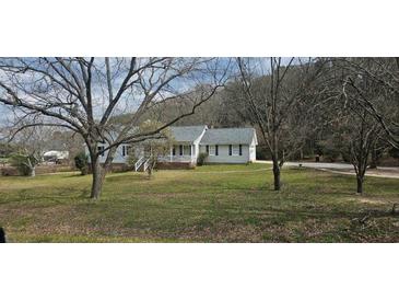 Charming one-story home with a well-manicured lawn and mature trees providing shade at 4055 Haralson Mill Ne Rd, Conyers, GA 30012