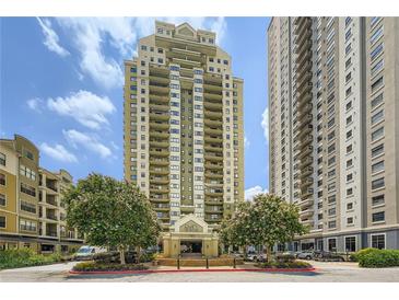 Exterior view of the residence with a walkway and trees in front of a high rise building on a partly cloudy day at 799 Hammond Dr # 427, Atlanta, GA 30328