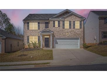 Charming two-story brick home with a two-car garage and well-maintained front lawn at 1936 Waycross Ln, Dacula, GA 30019