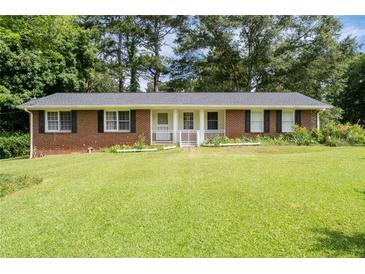 Charming brick ranch-style home with a well-manicured front lawn and a welcoming porch at 999 Chestnut Oak Ct, Lawrenceville, GA 30046