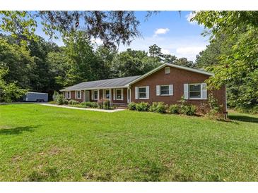 Charming one-story brick home with white shutters and a lush green lawn at 1051 Rock Springs Rd, Lawrenceville, GA 30043