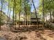 Backyard view of the deck and home featuring lush greenery and mature trees at 819 Bermuda Run, Woodstock, GA 30189