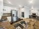 Modern kitchen boasts stainless steel appliances, granite countertops, white cabinetry, and a view to the Gathering room at 819 Bermuda Run, Woodstock, GA 30189