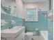 Classic bathroom featuring retro blue tiling, a sink with mirror and window, a toilet, and a bathtub at 3159 Nursery Se Rd, Smyrna, GA 30082