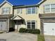 Two-story townhome with light yellow siding and a two-car garage at 4415 Stone Gate Way, Atlanta, GA 30344