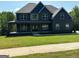 Beautiful two-story home featuring a covered porch, stone accents, and a well-manicured lawn at 5484 Two Hills Dr # 32, Fairburn, GA 30213
